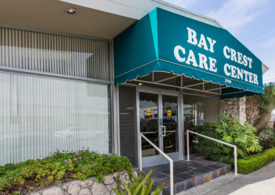 Teal Bay Crest Care Center awning and front entrance of building.