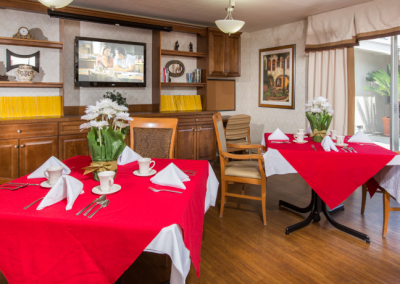 Bay Crest center's dining room with bright red table cloths and a view of the outside patio.